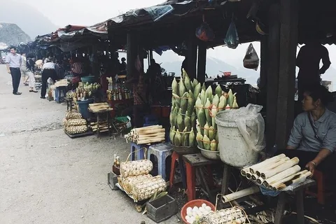 Các quầy hàng bên đường bán bắp và cơm lam trên đèo núi mờ sương gần Pù Luông.