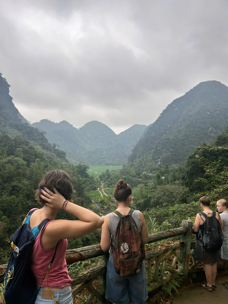 Du khách dừng chân bên hàng rào gỗ ngắm thung lũng xanh giữa những dãy núi đá vôi ở Pù Luông.