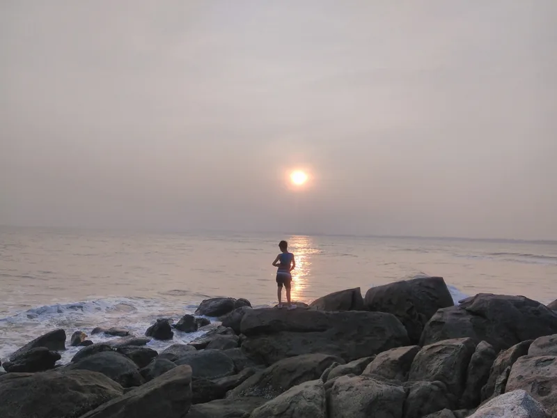 Một người đứng trên đá ngắm hoàng hôn trên biển tại bãi biển Sầm Sơn, Thanh Hóa.